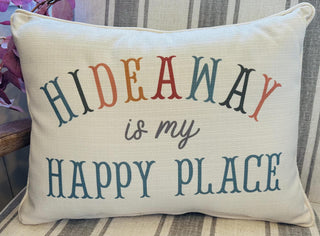 Hideaway Is My Happy Place decorative throw pillow with colorful typography on a neutral fabric.