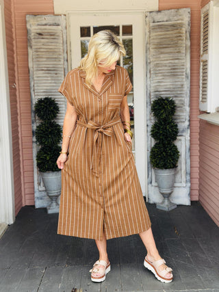 Kimberly Dress in brown striped fabric featuring button front detail, waist tie, and midi length silhouette