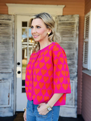 Pink and red heart print short sleeve sweater with heart buttons

Ivy Jane pink sweater with red heart pattern and button front

Heart felt pink sweater top with short sleeves and ribbed hem

Valentine heart print sweater top by Ivy Jane

Pink knit heart sweater with red hearts and decorative buttons