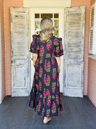 Black floral puff sleeve dress with pink and mustard blooms

Elora Dress in black featuring ruffled sleeves and floral print

Black tiered floral dress with ruffle collar and short sleeves