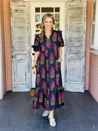 Black floral puff sleeve dress with pink and mustard blooms

Elora Dress in black featuring ruffled sleeves and floral print

Black tiered floral dress with ruffle collar and short sleeves