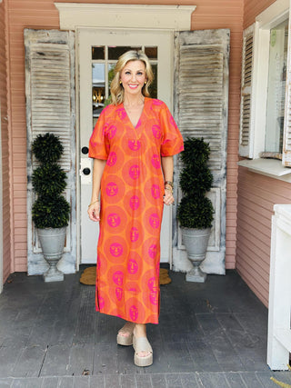 Uncle Frank Here Comes The Sun Dress in hot pink and orange print featuring sun face pattern, deep v-neckline, and side slit