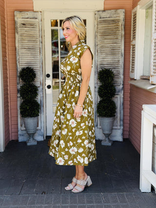 Drew Dress in a black floral print featuring a front zip neckline, drop shoulders, smocked waist, midi length, and side pockets.