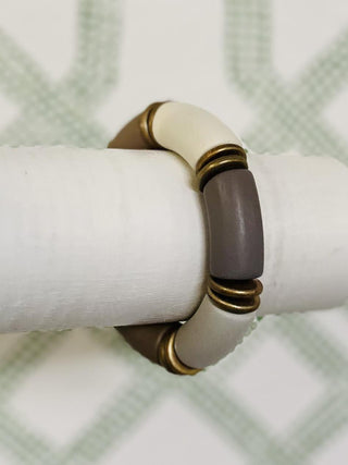 Stretchy bracelet with neutral-toned segments and gold accent rings

Brinley bracelet featuring taupe, ivory, and bronze chunky beads

Neutral colorblock bracelet with metallic accents

Earth-tone stretch bracelet with matte and glossy finishes