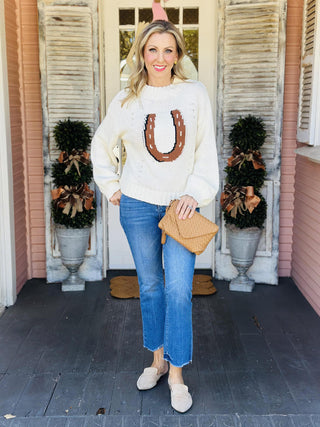 Woman wearing ivory knit horseshoe sweater with cowboy hat

Western-style ivory sweater with brown horseshoe design

Dolly Sweater with bold horseshoe motif and relaxed fit

Ivory Western knit sweater with ribbed hem and sleeves

Cozy horseshoe intarsia sweater with long sleeves