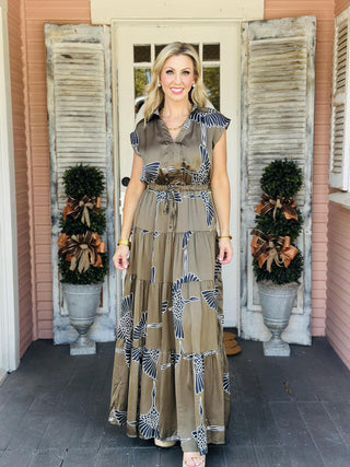 Indie Dress in olive with white bird print and tiered maxi silhouette

Cap sleeve maxi dress with collar, V-neckline, and self-tie waist

Olive green tiered maxi dress featuring bold white bird pattern

Indie Dress with collared V-neck, tiered skirt, and waist tie

Sleeveless maxi dress with cap sleeves and statement bird print
