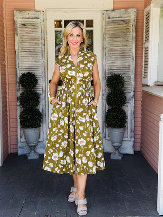 Drew Dress in a black floral print featuring a front zip neckline, drop shoulders, smocked waist, midi length, and side pockets.
