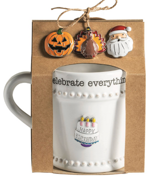 Simply Charming Holiday Mug Set featuring a white beaded ceramic mug with interchangeable magnetic holiday charms including a jack-o'-lantern, turkey, Santa, and birthday cake.