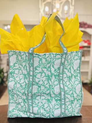 Green Gardenia quilted tote bag with matching makeup pouch

Quilted green floral tote bag with striped handles and zipper pouch

Green floral quilted tote bag filled with yellow tissue paper

Lightweight quilted tote bag with botanical print and makeup bag