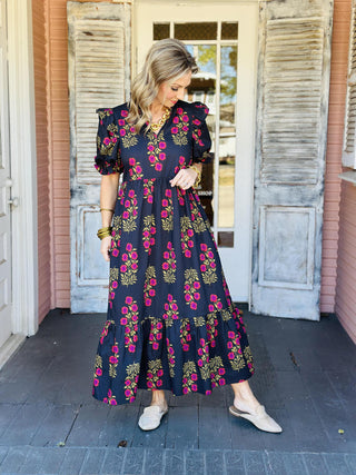 Black floral puff sleeve dress with pink and mustard blooms

Elora Dress in black featuring ruffled sleeves and floral print

Black tiered floral dress with ruffle collar and short sleeves