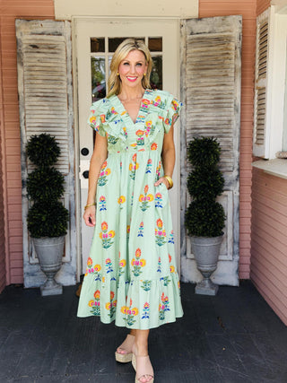 Sage green floral midi dress with flutter ruffle sleeves and ruched V-neck detail.