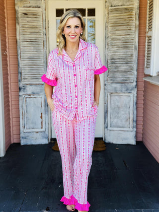 Oh So Lovely Pajama Pants Set with pink heart print, ruffled sleeves, and ruffle hem pants

Pink button-down pajama set with heart pattern and ruffle details

Women’s ruffled pajama pants set with drawstring waist and button-front top

Romantic heart print pajama set with ruffled sleeves and pant cuffs