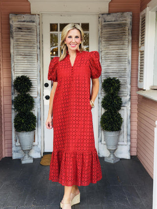 Katrina Dress in rust eyelet fabric featuring short puff sleeves, a ruffled mock neckline, button-front closure, and midi-length ruffle hem.