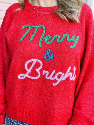 Red “Merry & Bright” Christmas sweater with colorful lettering

Festive red holiday pullover with green, blue, and white embroidery

Cozy red “Merry & Bright” knit sweater for the holidays