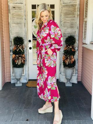 "Ava Center Stage Plum Dress with bold floral print, button front, and tie waist"

"Long sleeve plum midi dress with oversized pink and green floral pattern and belted waist"

"Women’s floral shirt dress in plum with button-down front, tie belt, and flowy silhouette"