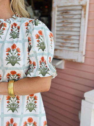 Floral puff sleeve blouse with tieable v-neck and orange flower block print


