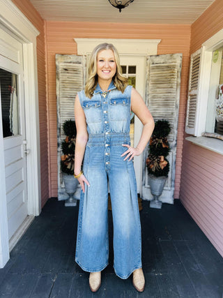 Woman wearing sleeveless wide-leg denim jumpsuit

Light wash denim jumpsuit with button front and wide legs

Collared sleeveless denim jumpsuit with pleats

Snow washed denim jumpsuit styled with boots

Wide leg chambray jumpsuit with front pockets