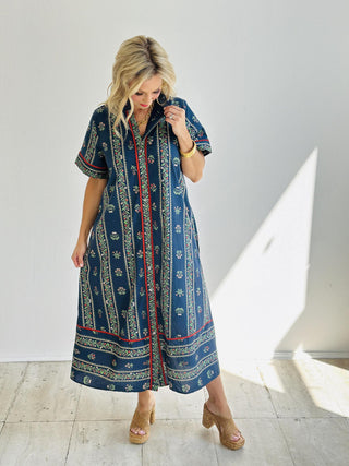 Woman wearing the Melina Dress, navy floral print midi shirt dress with belt

Melina Dress in linear floral pattern with contrast red accents

Short sleeve floral button-front shirt dress with pleated ruffle neckline

Navy floral midi dress with pockets and removable waist belt