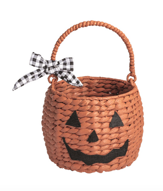 Woven seagrass Halloween treat baskets featuring pumpkin, ghost, and pink jack-o'-lantern designs with felt facial details and decorative ribbon bows.