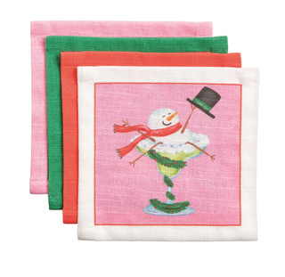 Set of four cotton holiday cocktail napkins featuring festive Christmas illustrations including a snowman cocktail, Santa, reindeer, and champagne celebration.