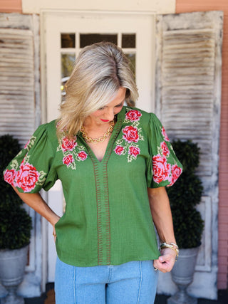 Green Kenleigh Top with red and pink floral embroidery, V-neckline, and puff sleeves.