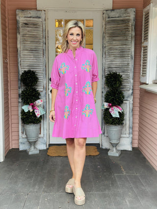 Ivy Jane Evie Dress in bright pink cotton with turquoise blocked floral embroidery, puff sleeves, pintuck front, and button-down design.