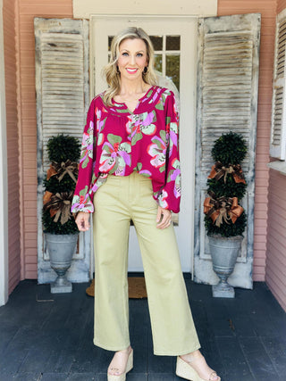 "Janelle Center Stage Plum Top with bold floral print and long sleeves"

"Plum blouse with oversized pink and green floral pattern and ruffle neckline"

"Women’s floral long sleeve top in plum with gathered neckline and relaxed fit"