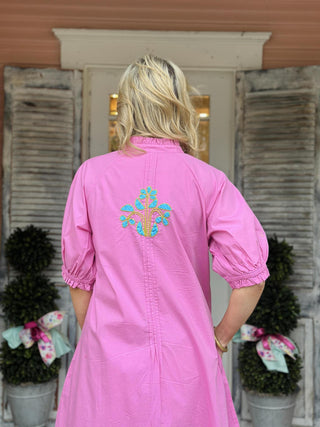 Ivy Jane Evie Dress in bright pink cotton with turquoise blocked floral embroidery, puff sleeves, pintuck front, and button-down design.