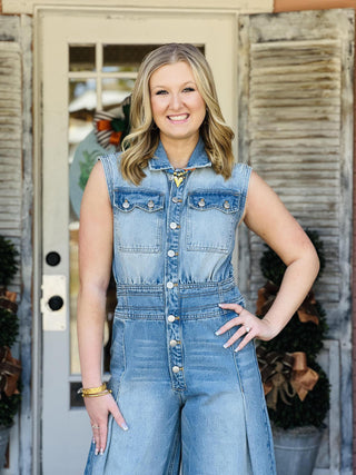 Woman wearing sleeveless wide-leg denim jumpsuit

Light wash denim jumpsuit with button front and wide legs

Collared sleeveless denim jumpsuit with pleats

Snow washed denim jumpsuit styled with boots

Wide leg chambray jumpsuit with front pockets