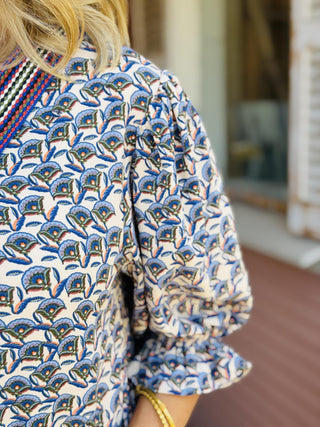Collins Rae Dress in taupe and blue floral print featuring puff sleeves, a contrast V-neckline, mini length, and side pockets.