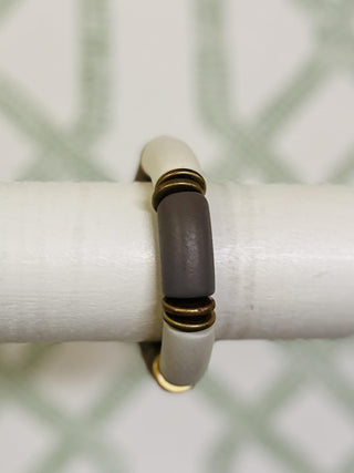 Stretchy bracelet with neutral-toned segments and gold accent rings

Brinley bracelet featuring taupe, ivory, and bronze chunky beads

Neutral colorblock bracelet with metallic accents

Earth-tone stretch bracelet with matte and glossy finishes