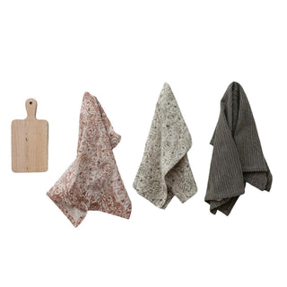 Stonewashed cotton tea towels with floral and stripe patterns paired with mango wood serving board