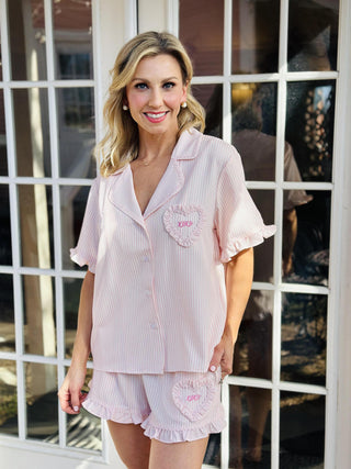 Pink striped Valentine ruffled pajama set with short sleeves and shorts

Valentine ruffle pajamas with ric rac trim and heart pocket detail

Pink striped short sleeve pajama top and shorts with ruffle hem

Women’s Valentine pajama set with ric rac trim and heart accents

Cute Valentine sleepwear set with ruffles and striped fabric