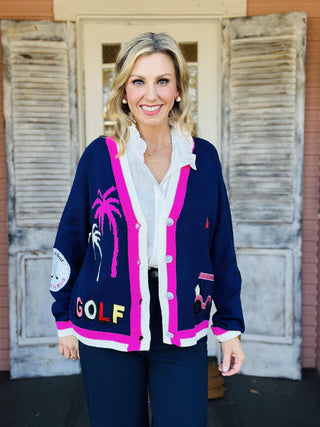 Navy golf embroidered patch cardigan with pink trim and playful golf motifs, front view

Golf-themed cardigan with embroidered patches and button front, women’s novelty knit sweater

Back view of navy golf cardigan featuring “Par Tee Time” embroidery and pink putting green design