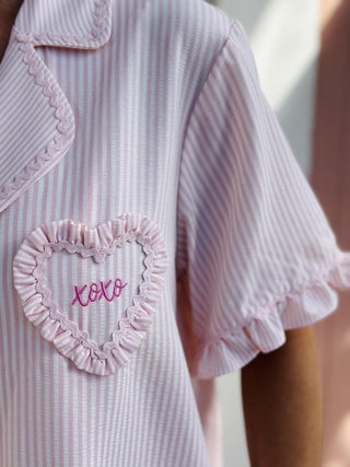 Pink striped Valentine ruffled pajama set with short sleeves and shorts

Valentine ruffle pajamas with ric rac trim and heart pocket detail

Pink striped short sleeve pajama top and shorts with ruffle hem

Women’s Valentine pajama set with ric rac trim and heart accents

Cute Valentine sleepwear set with ruffles and striped fabric