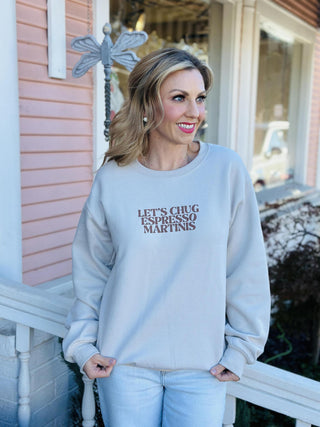 Let’s Chug Espresso Martinis crewneck sweatshirt in cream

Neutral crewneck with brown espresso martini graphic text

Cozy beige sweatshirt with Let’s Chug Espresso Martinis lettering

Trendy coffee-inspired crewneck in neutral cream color

Cream graphic sweatshirt with espresso martini slogan