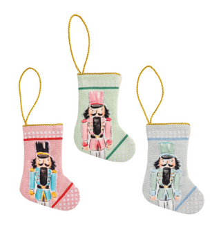Mini Nutcracker Stockings featuring colorful needlepoint nutcracker designs, canvas backing, and cotton cord hanging loops.