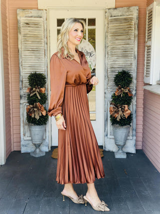 Woman wearing satin pleated bronze midi dress

Long sleeve surplice satin dress with pleated skirt

Shiny copper brown woven satin midi dress with collar