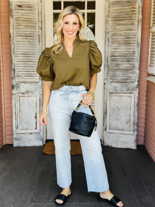 Woman wearing olive green ruffle v-neck top with puff sleeves

Olive green short sleeve blouse with textured fabric and gathered shoulders

Emory Top with puffed sleeves and ruffled neckline in textured olive fabric