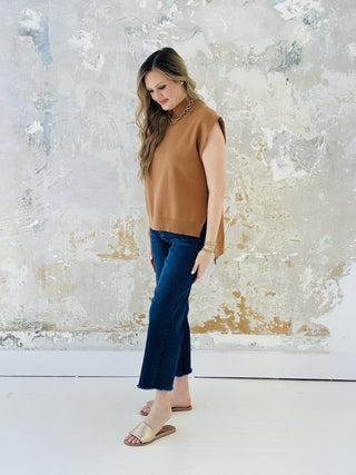 Woman wearing Jennifer Top, camel mock neck muscle tee knit pullover

Jennifer Top in solid camel with hi-lo hemline and sleeveless design

Solid knit mock neck top with modern muscle tee cut

Jennifer Top styled with floral print trousers and gold jewelry