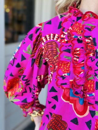 Bright pink Sabrina Charming Top with ruffles and bold print

Colorful patterned blouse with snakes, hearts, and ruffled neckline

Pink ruffle-front top with vibrant artistic print

Statement blouse with whimsical multicolor pattern and buttons