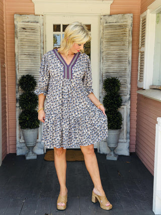  Collins Rae Dress in taupe and blue floral print featuring puff sleeves, a contrast V-neckline, mini length, and side pockets.