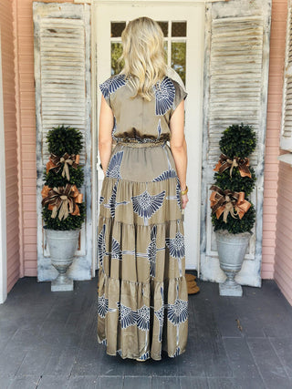Indie Dress in olive with white bird print and tiered maxi silhouette

Cap sleeve maxi dress with collar, V-neckline, and self-tie waist

Olive green tiered maxi dress featuring bold white bird pattern

Indie Dress with collared V-neck, tiered skirt, and waist tie

Sleeveless maxi dress with cap sleeves and statement bird print