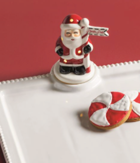 Hand-painted ceramic Santa Light-Up Sitter with built-in LED lights, classic red suit, and North Pole sign on a white display base.