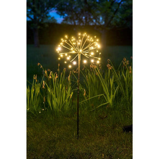 Solar powered garden stake lights shaped like dandelions glowing at night