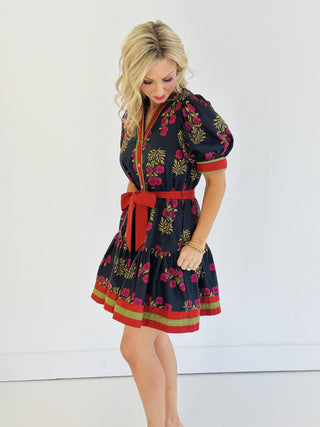 Woman wearing Abby Dress, black floral mini dress with puff sleeves and red belt

Abby Dress with ruffle hem, multicolor accent bands, and button-front closure

Short puff sleeve floral print dress with removable waist belt

Tiered floral mini dress with V-neck collar and side pockets