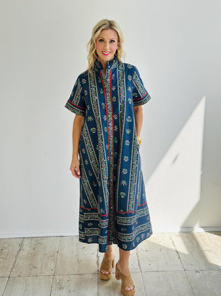 Woman wearing the Melina Dress, navy floral print midi shirt dress with belt

Melina Dress in linear floral pattern with contrast red accents

Short sleeve floral button-front shirt dress with pleated ruffle neckline

Navy floral midi dress with pockets and removable waist belt