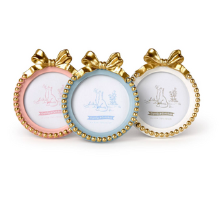Pink, blue, and white round photo frames with gold bows

Gold beaded round photo frames with bow detail

Assorted pastel round frames with gold bow top

Elegant nursery photo frames with gold trim and bow
