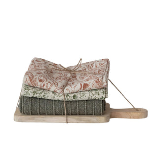 Stonewashed cotton tea towels with floral and stripe patterns paired with mango wood serving board
