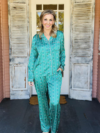 Green Charlotte In A Bow Christmas Pajama Set with festive bow print

Women’s green holiday pajama set with bow pattern and button top

Christmas pajama set with green satin finish and drawstring pants

Green festive sleep set with bow print and long sleeves

Charlotte In A Bow Pajama Set with classic button-up top